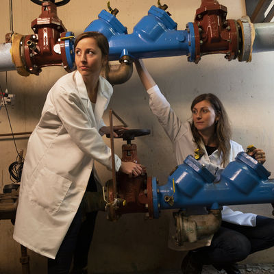 Faculty member Heather Murphy and a student conduct research on water pipes