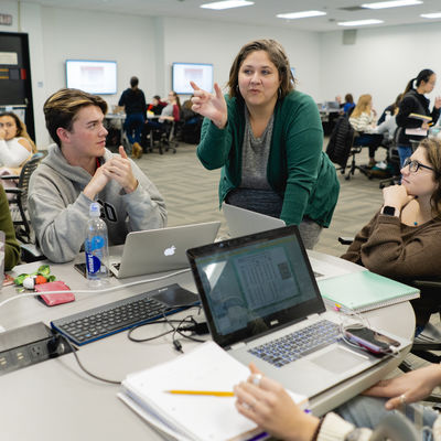 Assistant Professor of Instruction Felicidad Garcia speaks with a group of four students in a classroom
