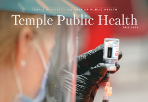 the cover of the college of public health 2021 magazine, depicting a nursing student filling a needle with covid-19 vaccine