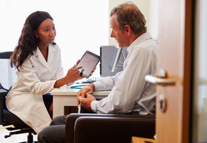 a doctor shows a patient information on a tablet