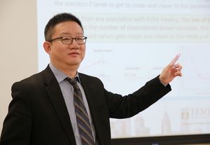 jingwei wu points to a projected screen in a classroom