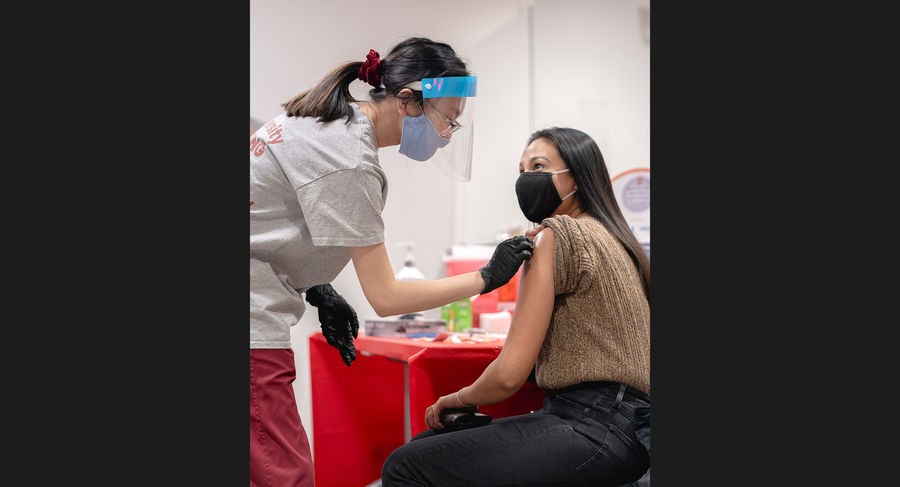 a student administers covid-19 vaccination