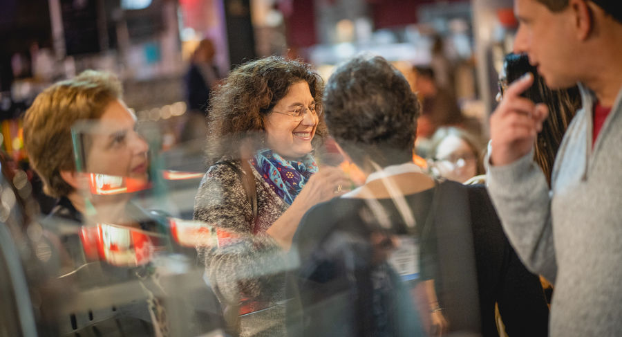 dean talks with guests at welcome reception