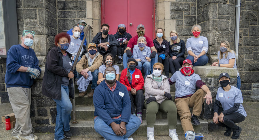 Group of volunteers sits outside church on front steps