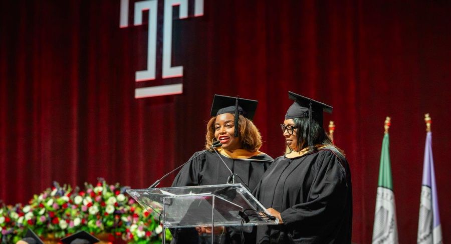 Janelle Lyons and Amina Mayazi-Saunders speak on the graduation stage.