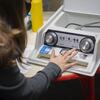 A student presses buttons on an audiology device