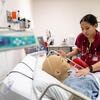 A nursing student tends to a manekin