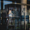 Student facing outside a window as the sun is setting