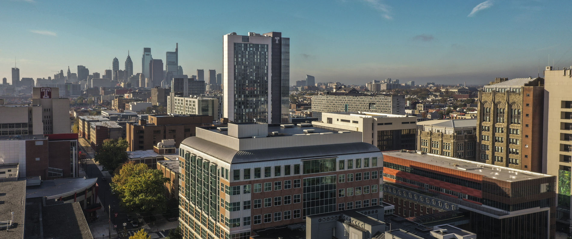 Looking over the tops of buildings at Temple University's Morgan Hall with the Philadelphia skyline visible in the background