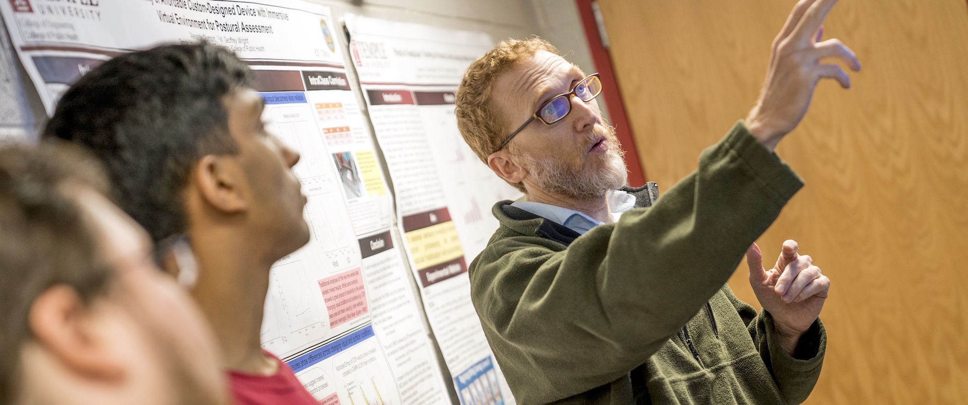 Professor Geoff Wright pointing at a research poster