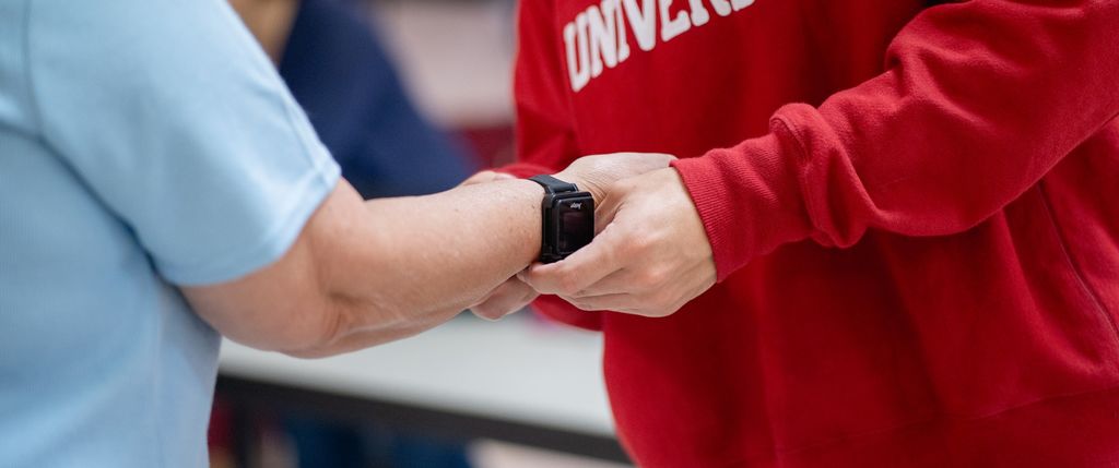 a student places a monitoring device on a person's wrist
