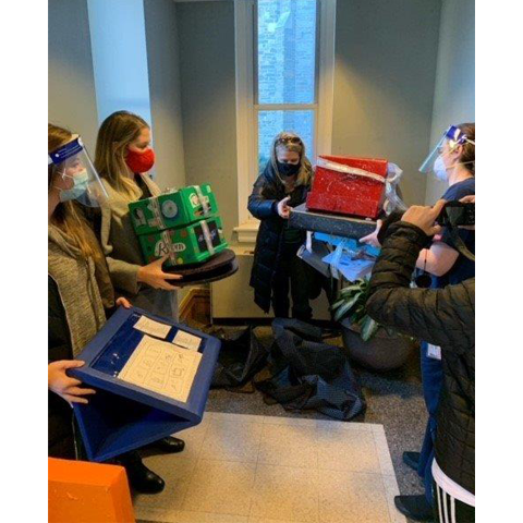 students standing in a circle, holding assistive technology devices