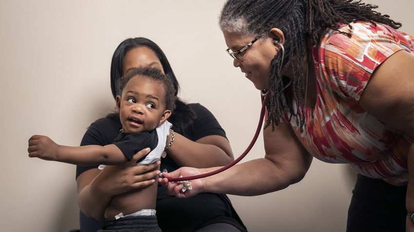Nurse using a stethoscope on a small boy