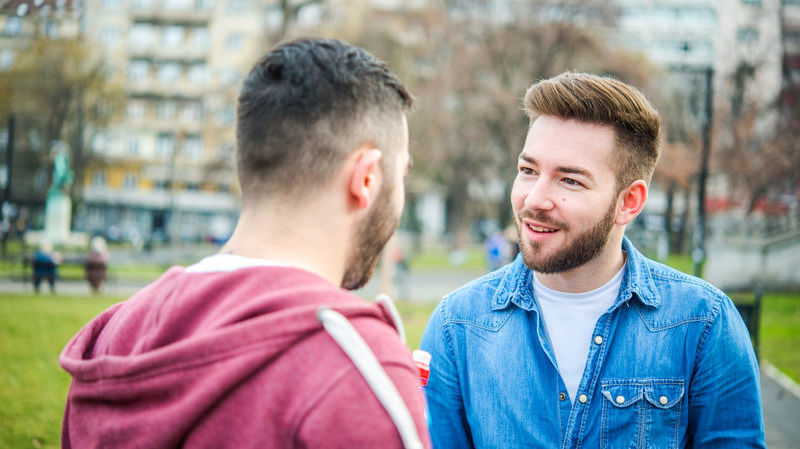 Two men talking to one another in a park