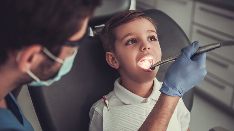 Dentist examining boy's teeth