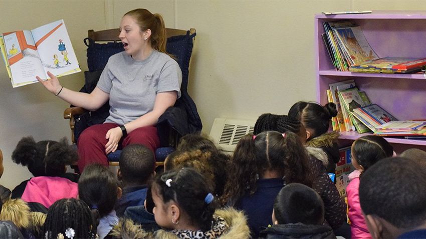 nursing student reads to group of children