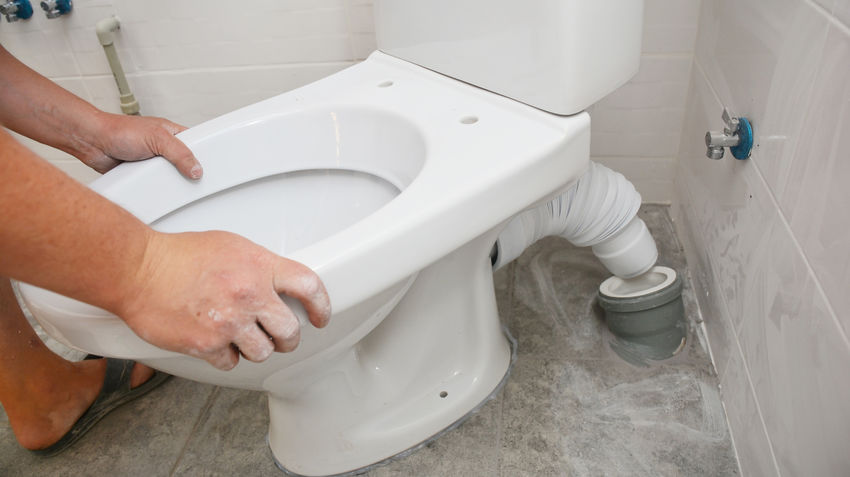 person installing toilet