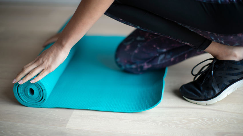 woman unrolling yoga mat