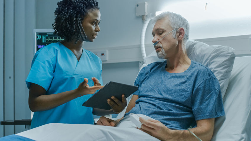patient and nurse communicating over a tablet