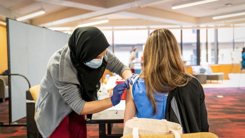 student giving a flu vaccine