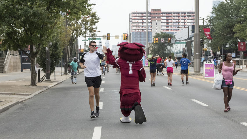 Hooter high fives people running on broad street