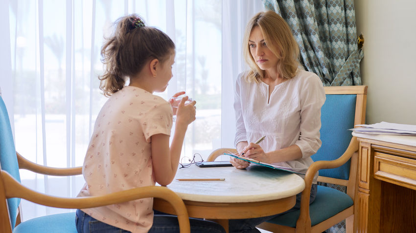 young girl and therapist talk in therapists office