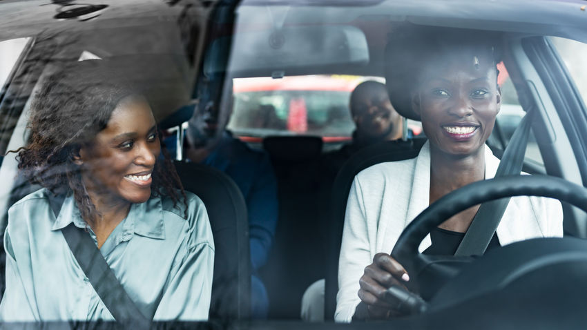 group of friends smiling in a car