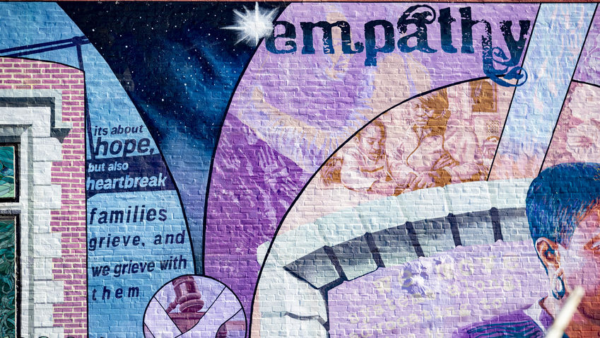 a mural depicting the word "empathy" and the phrase "its about hope, but also heartbreak. families grieve, and we grieve with them."