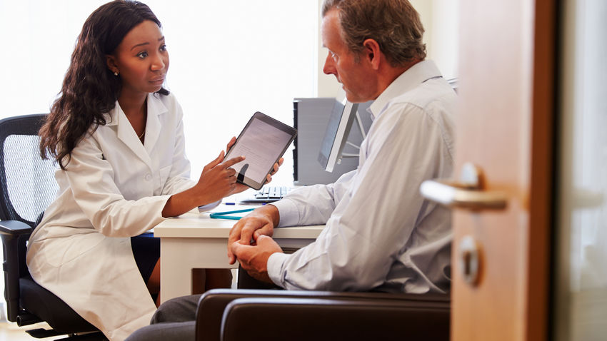 a doctor shows a patient information on a tablet