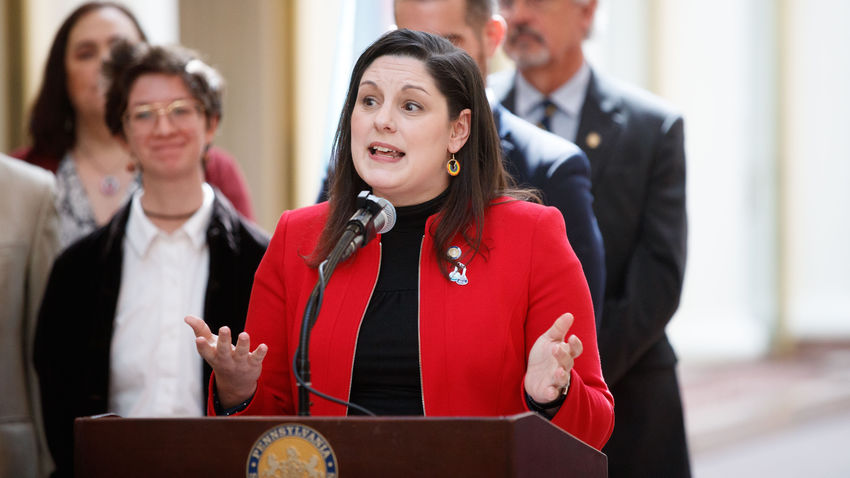 amanda cappelletti stands at a podium during a speech