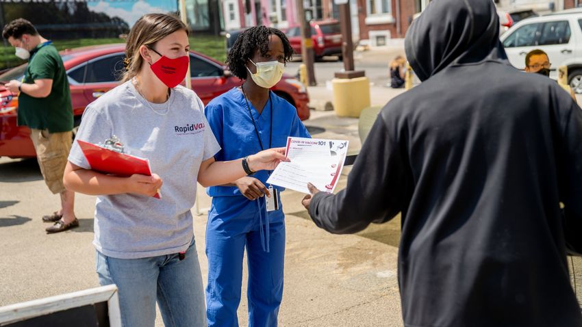 students handing out a flyer in a philadelphia neighborhood