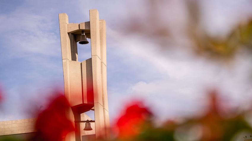 the belltower on temple main campus, with flowers in front of it 