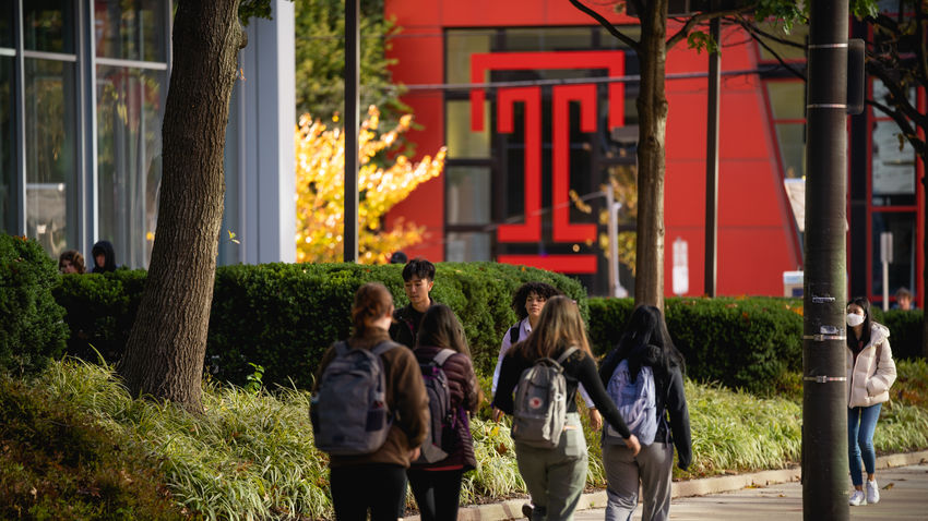 Students walk on the sidewalk near the student center 