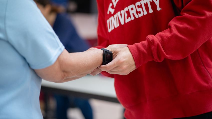 a student places a monitoring device on a person's wrist