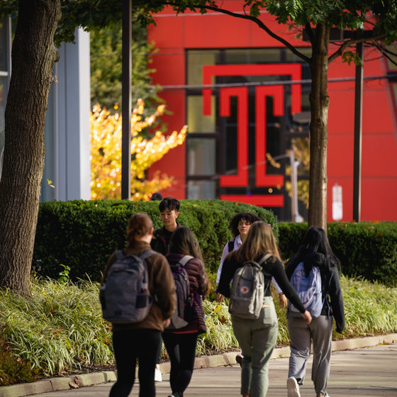 Students walk on the sidewalk near the student center 