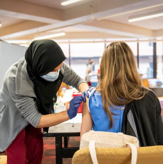 student giving a flu vaccine