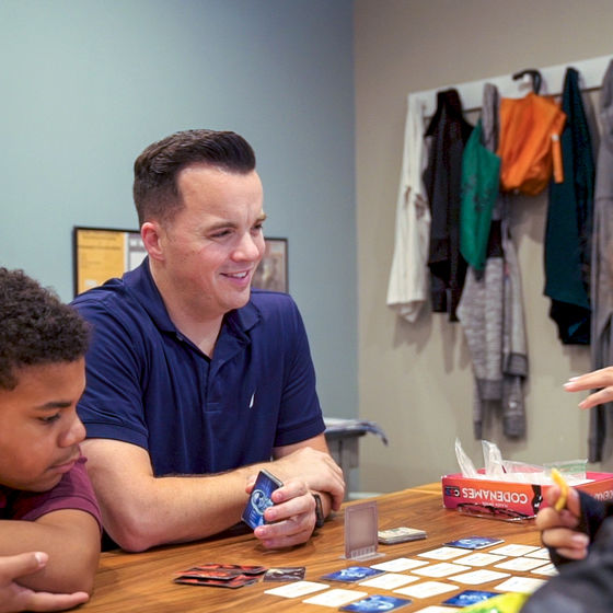 Tim Gallagher plays a board game with his students