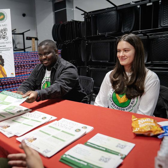 Undergraduate student workers Omari Coker and Molly Piacentini spoke with community members at the Boost Your Shot event at Kensington's Rock Ministries. 